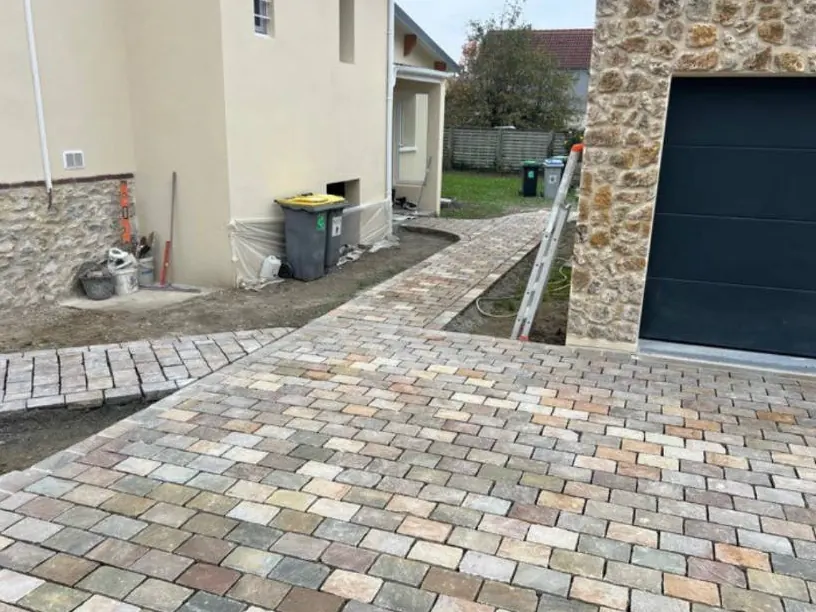 Cour pavée devant une porte de garage