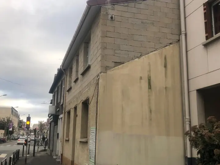 Façade de maison de ville en cours de ravalement, enduit neuf sur le pignon