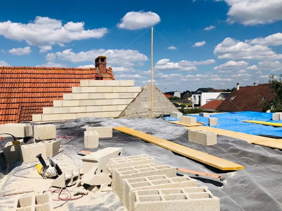Pignon monté en blocs béton sur un chantier de surélévation de maison