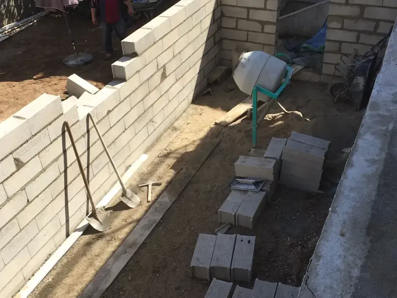 Mur de soutènement en parpaings en cours de montage