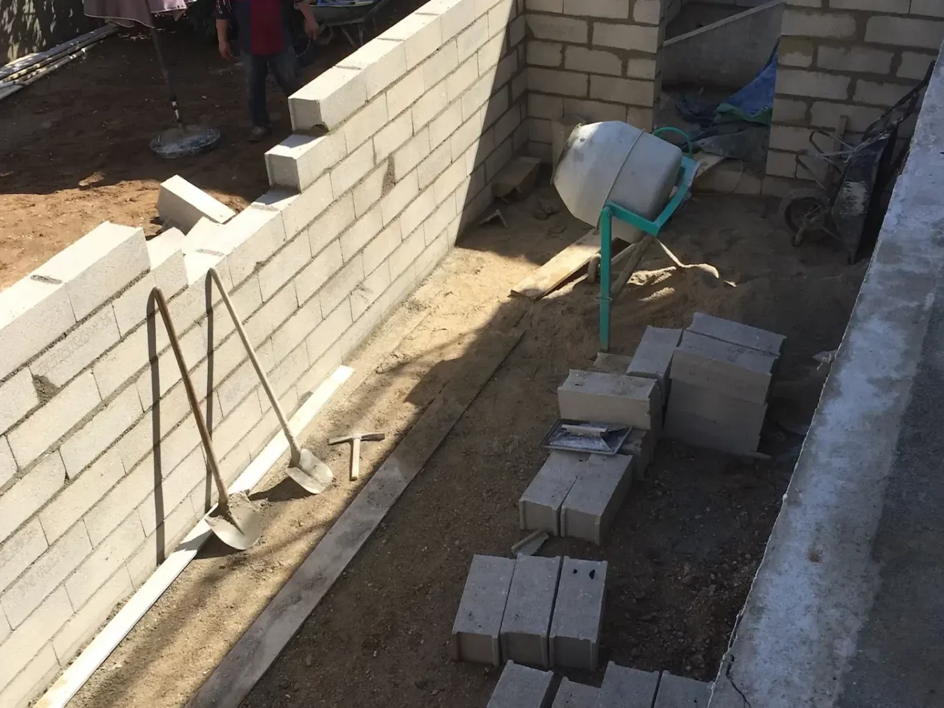 Mur de soutènement en parpaings en cours de montage
