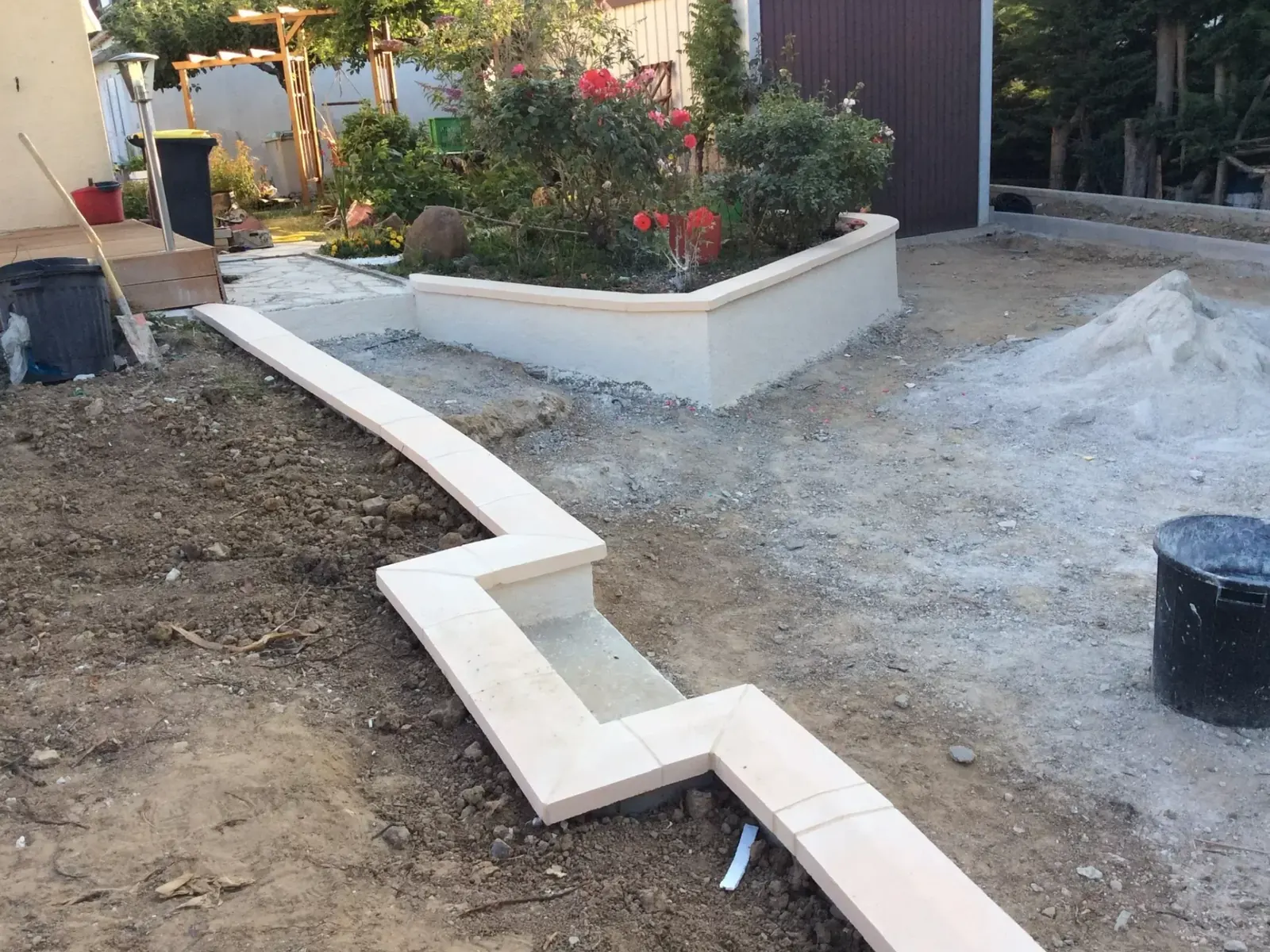 Murets béton délimitant une terrasse et un massif