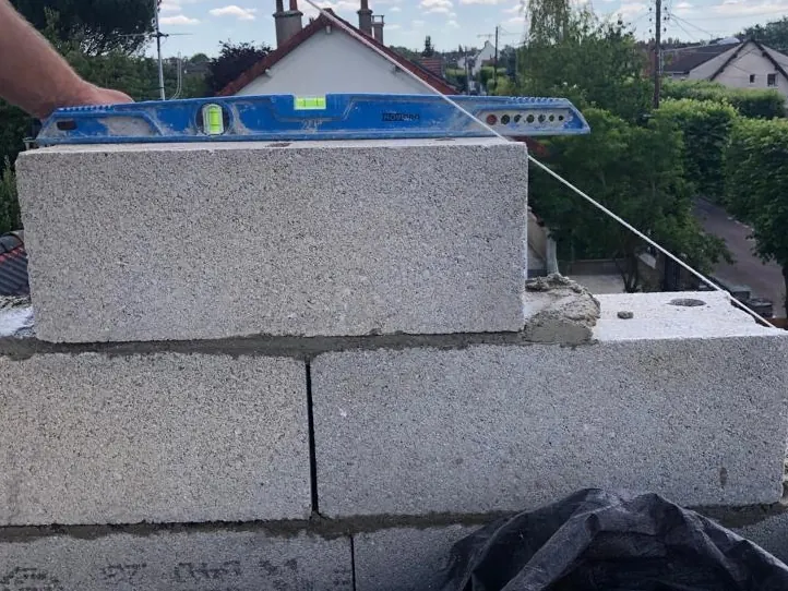 Contrôle au niveau d'un rang de blocs béton sur une surélévation