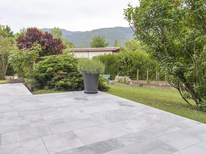 Grande terrasse carrelée ouverte sur le jardin