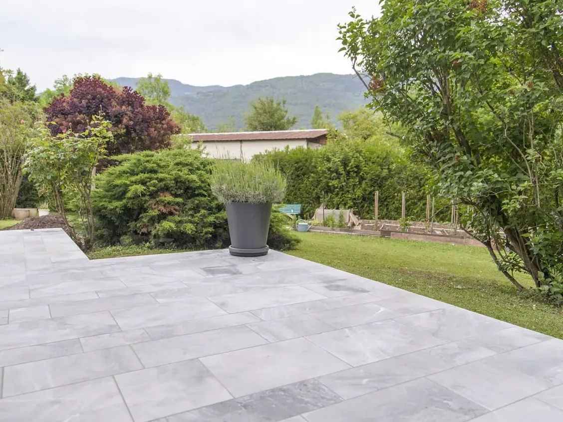 Grande terrasse carrelée ouverte sur le jardin