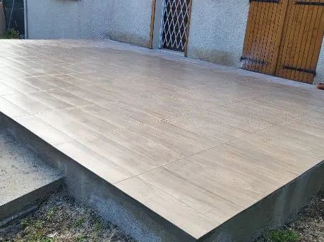 Terrasse carrelée surélevée au pied d'une maison