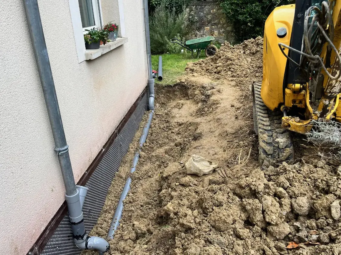 Tranchée de drainage ouverte à la mini-pelle au pied d'une maison